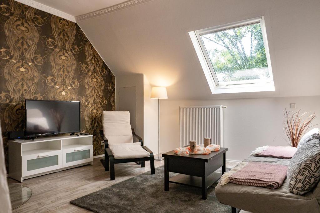 a living room with a couch and a tv at Appartment Rheinaue in Duisburg