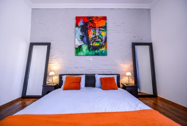 a bedroom with a bed and a painting on the wall at ATRIUM 22 Apartment in Sighişoara