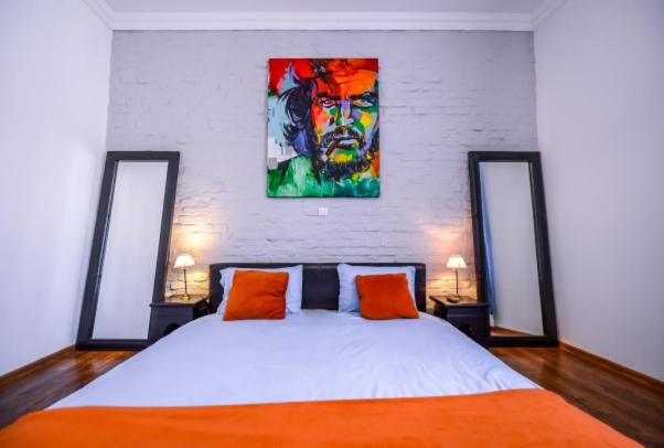 Un dormitorio con una cama y un cuadro en la pared. en ATRIUM 22 Apartment, en Sighişoara