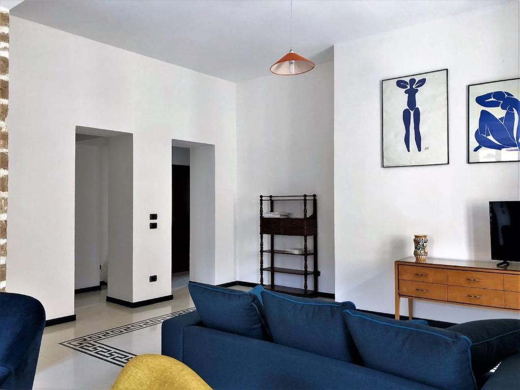 un soggiorno con divano blu e TV di ARDUINO AL TRE ad Alghero