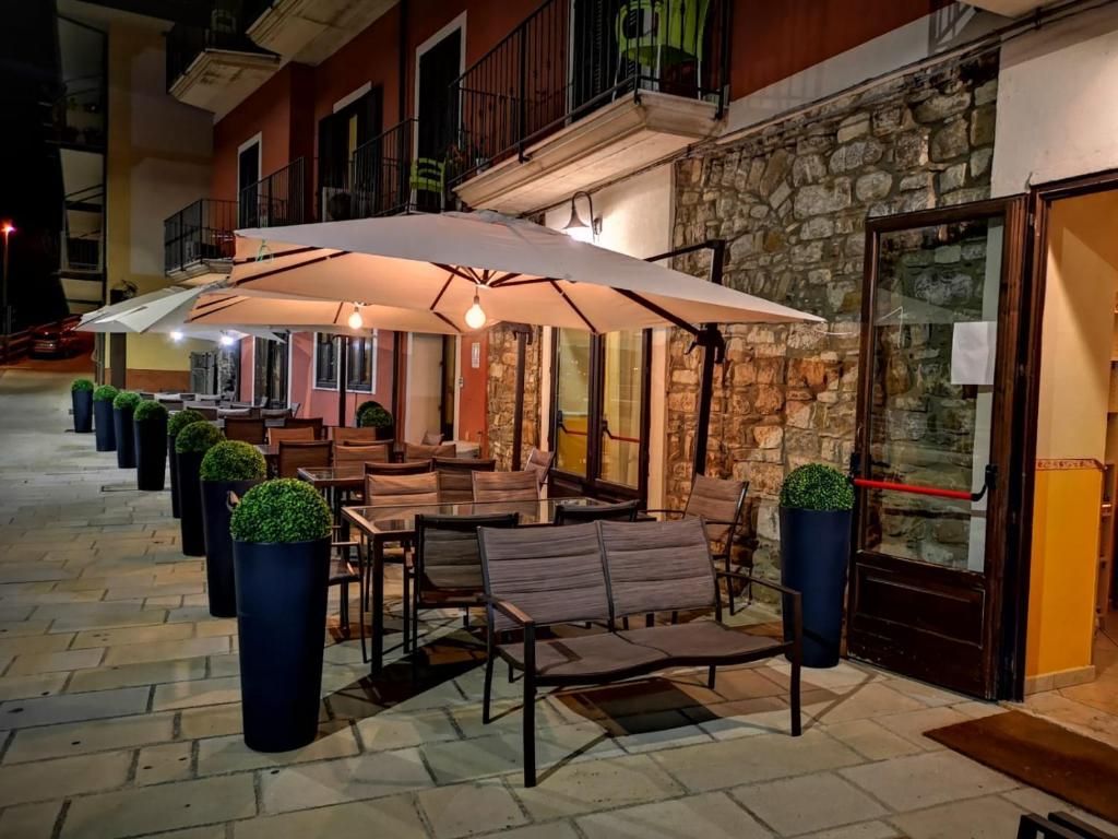 a patio with tables and chairs with umbrellas at Hotel La Rampa in Agnone
