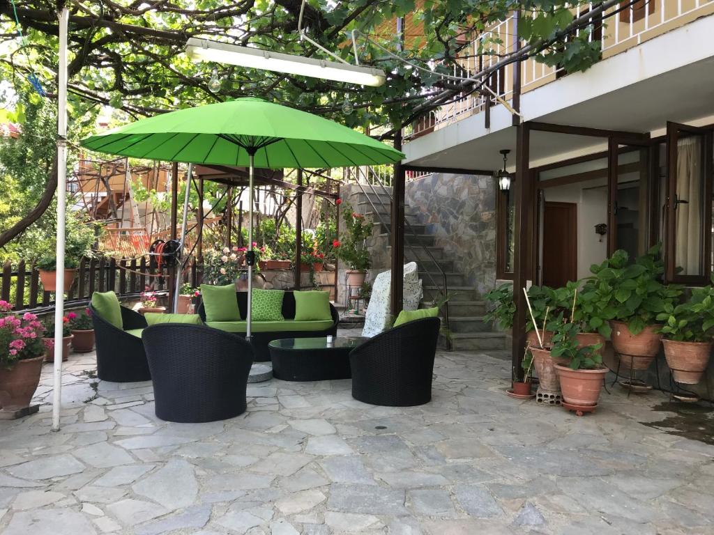 a patio with green chairs and an umbrella at Giannoullas Luxury2Bedroom House in Kalopanagiotis in Kalopanayiotis