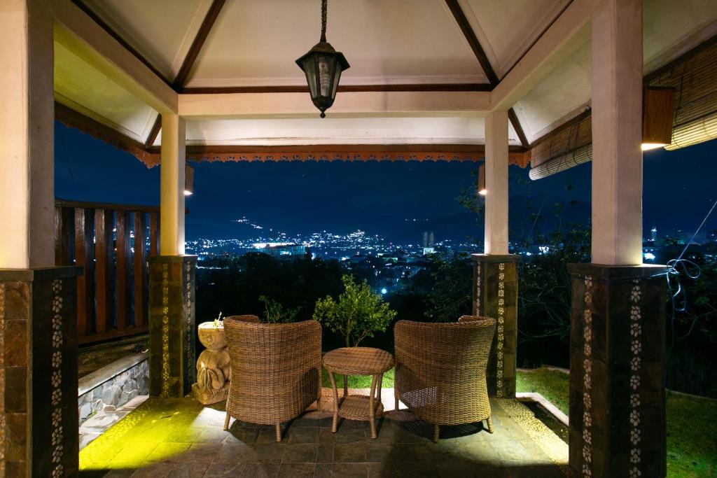 een veranda met stoelen en een tafel met uitzicht bij Shanty's House in Batu