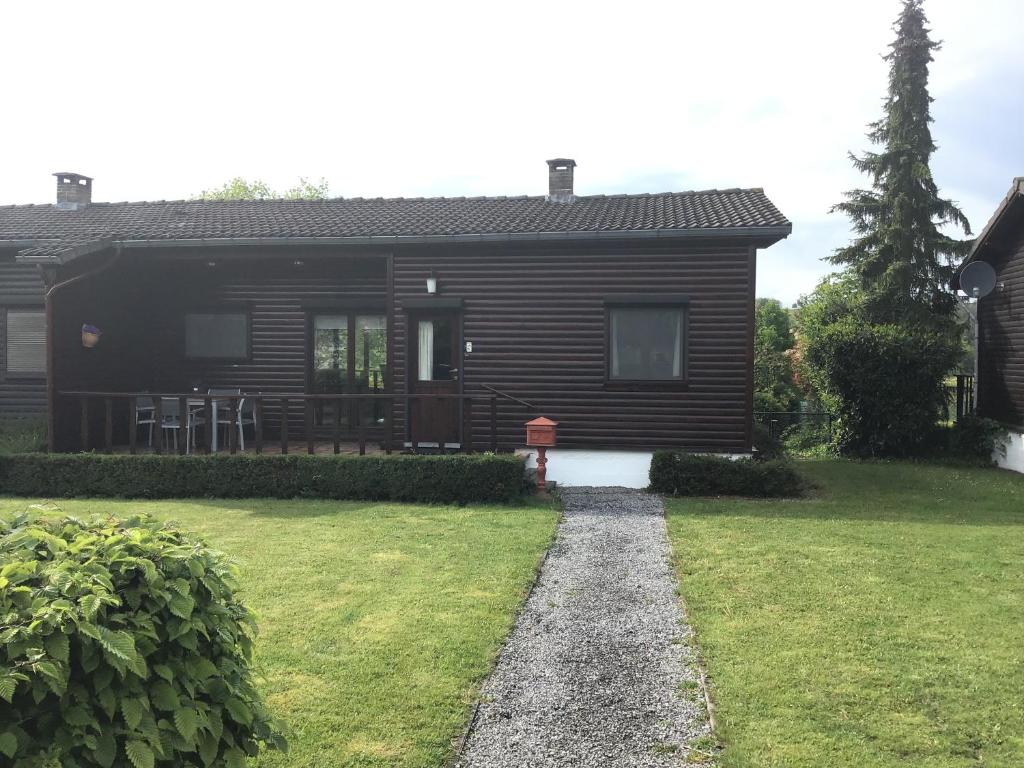 een huis met een grasveld ervoor bij Chalet Lizelle in Durbuy