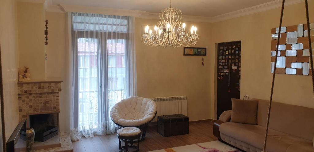 uma sala de estar com um sofá, uma cadeira e um lustre em Batusi Apartment em Batumi