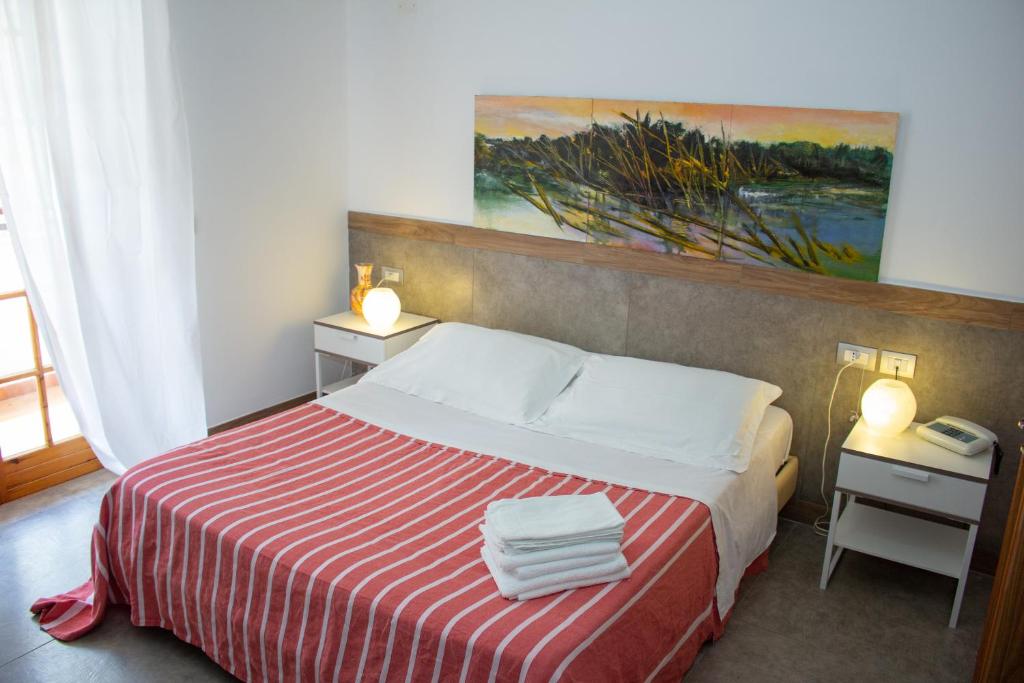 1 dormitorio con 1 cama con manta de rayas roja y blanca en Hotel Apeneste, en Mattinata
