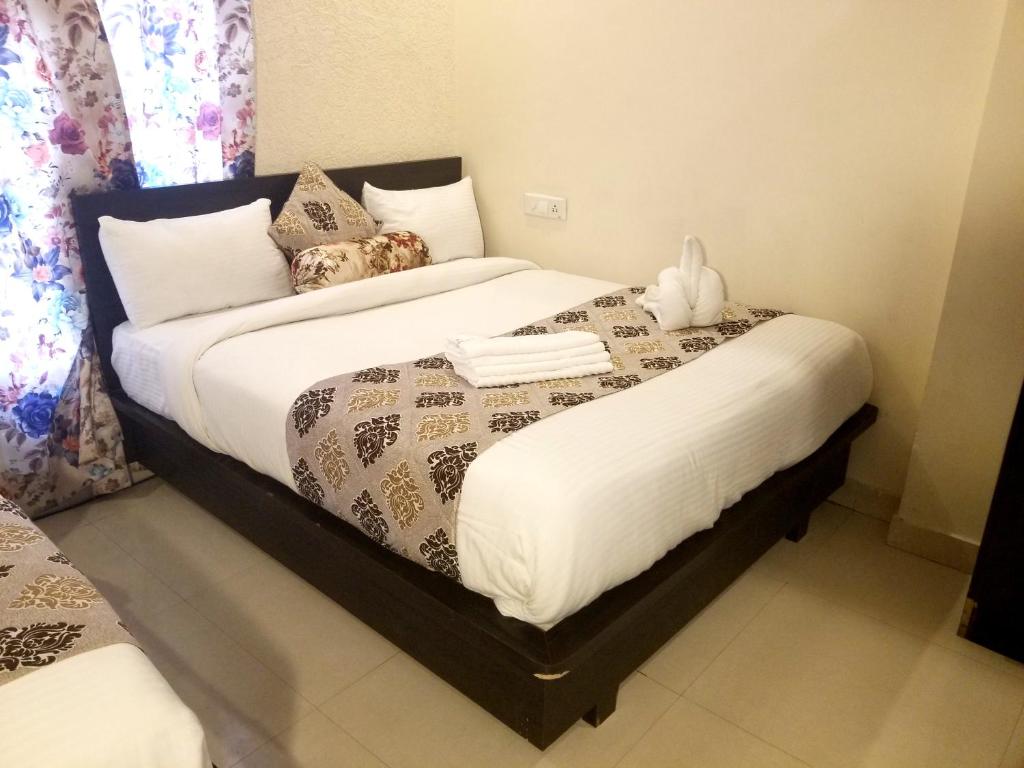a bedroom with a bed with a stuffed animal on it at Hotel Krishnas in Amritsar