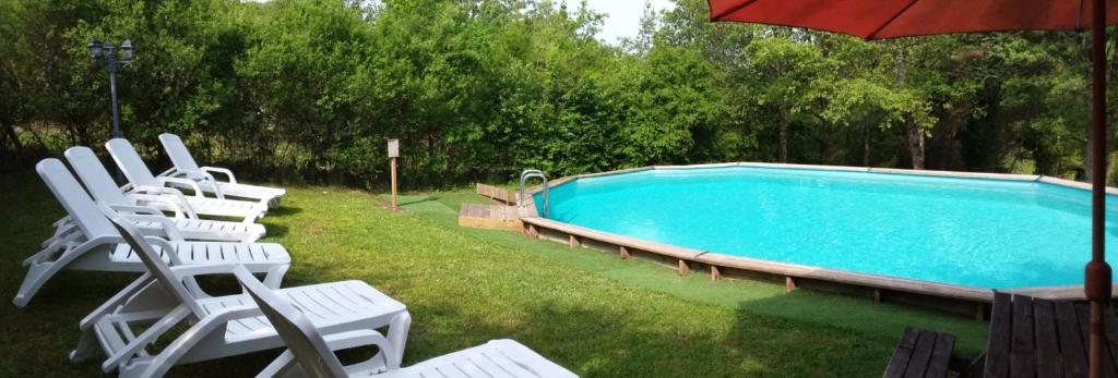 a group of chairs sitting next to a swimming pool at Studios Les Iris in Monthou-sur-Cher