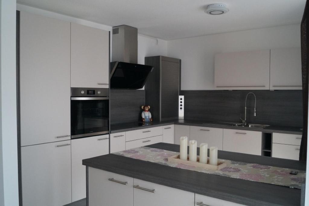 a kitchen with white cabinets and a black counter top at Ferienwohnung Weindler in Weiden