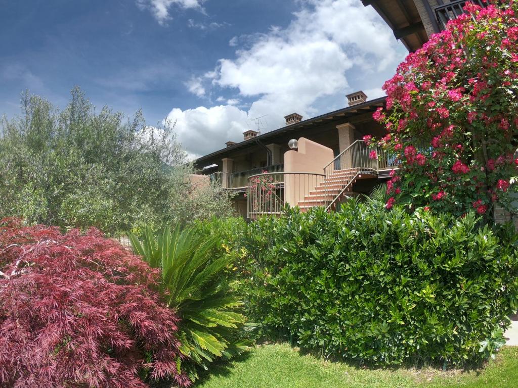 uma casa com um monte de arbustos e flores em Casa Gardenia em Toscolano Maderno