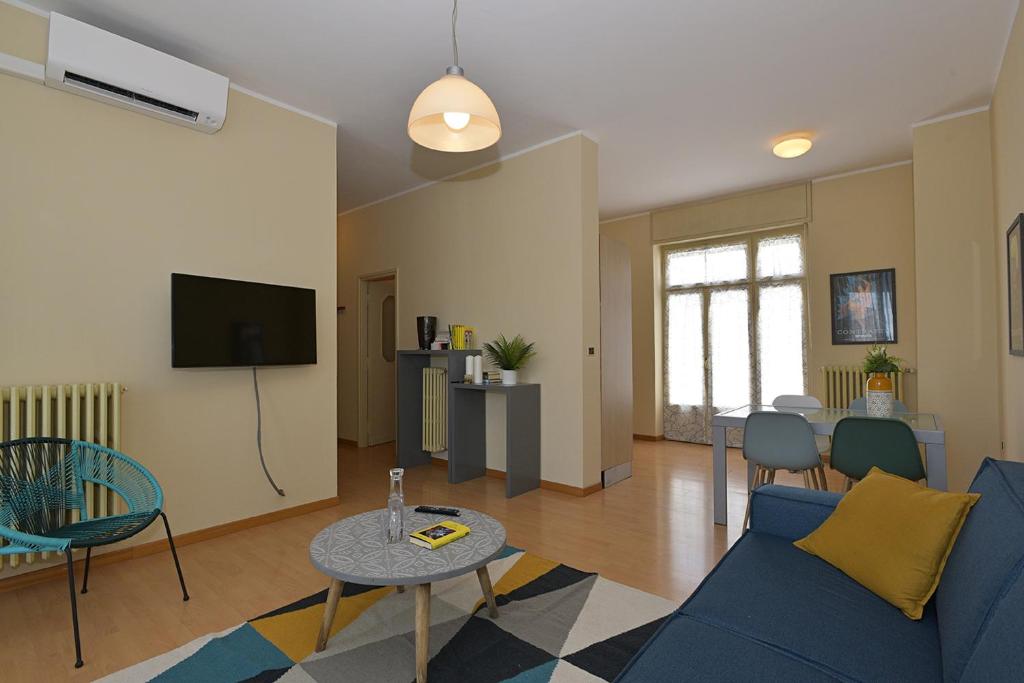 un soggiorno con divano blu e TV di Casa Dollu a Rivarolo Canavese