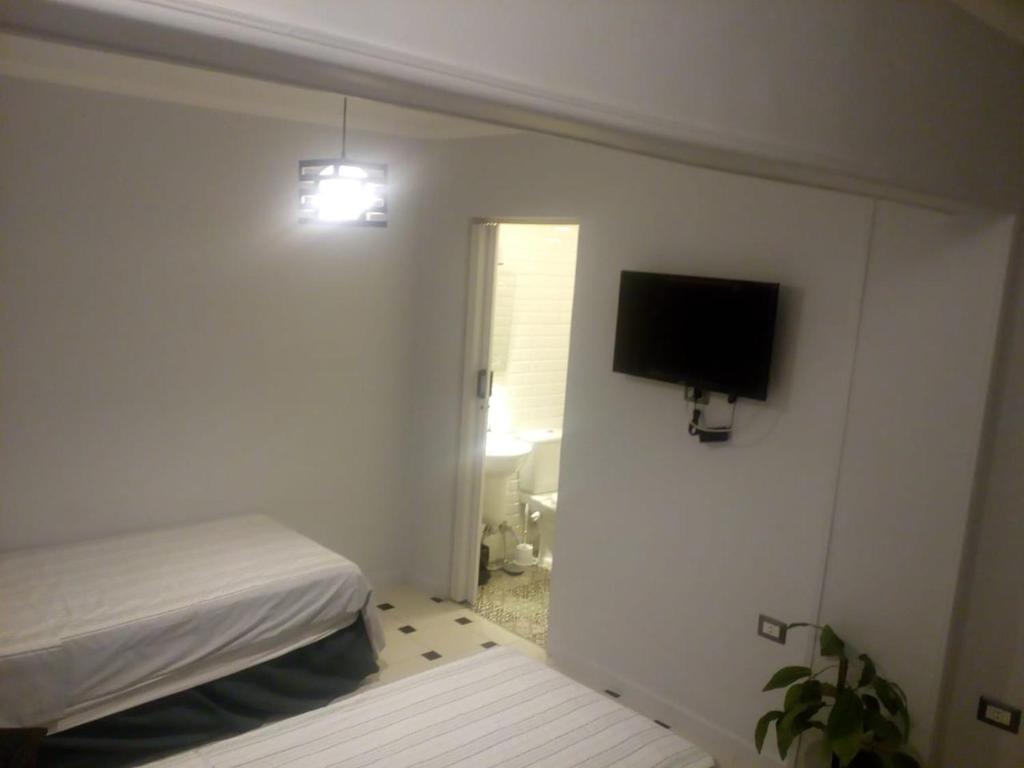 a bedroom with a bed and a flat screen tv at Venus Hostel in Cairo