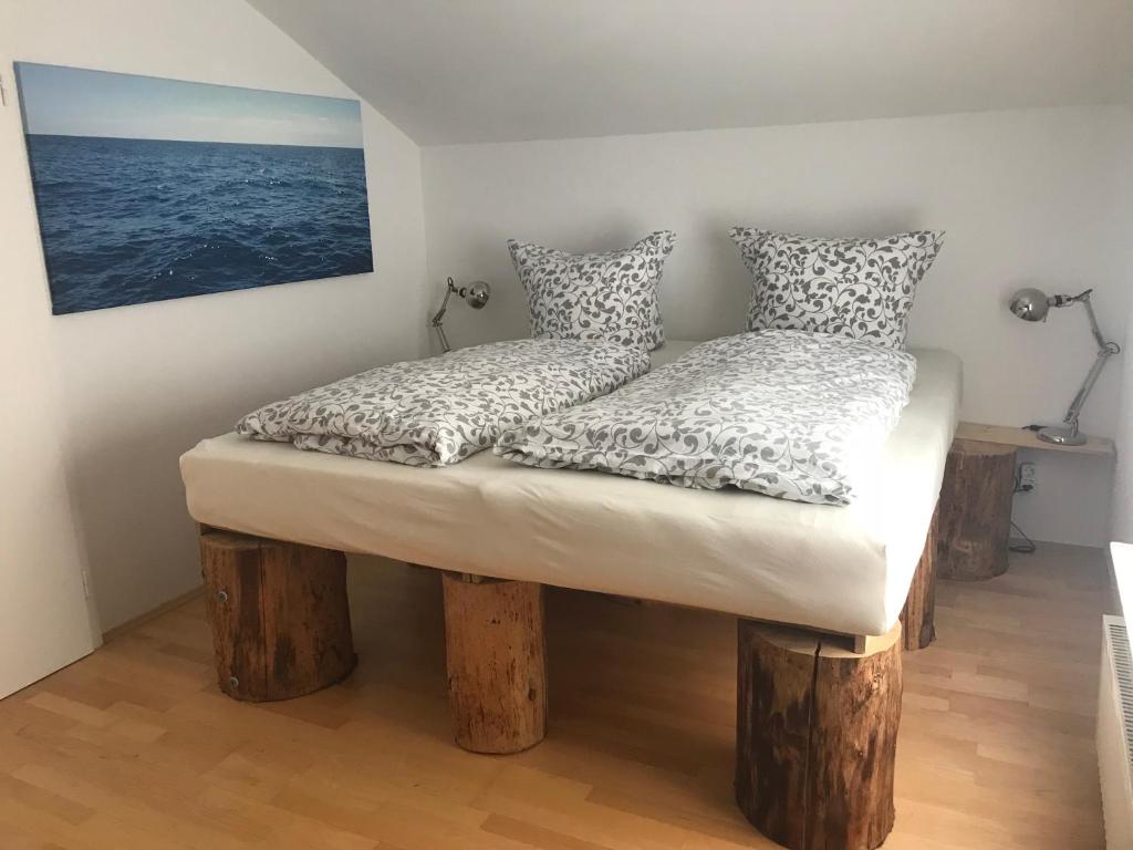 a bed with two pillows on logs in a room at Gästehaus Grabbe in Prien am Chiemsee