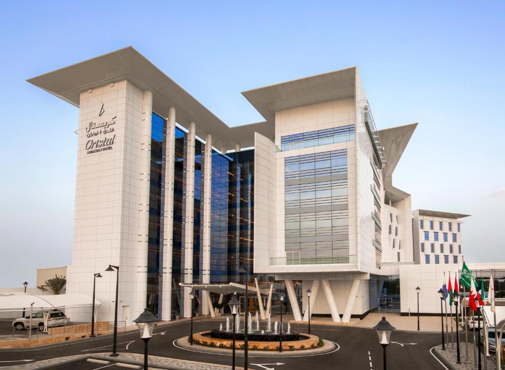 Cristal Amaken Hotel Riyadh في الرياض: مبنى ابيض كبير عليه لافته