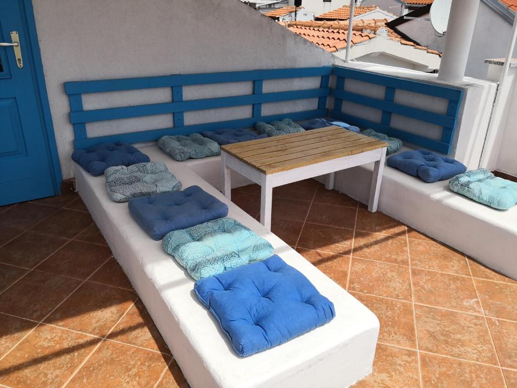 grupa ławek z niebieskimi poduszkami na balkonie w obiekcie Apartments Lighthouse w Bašce