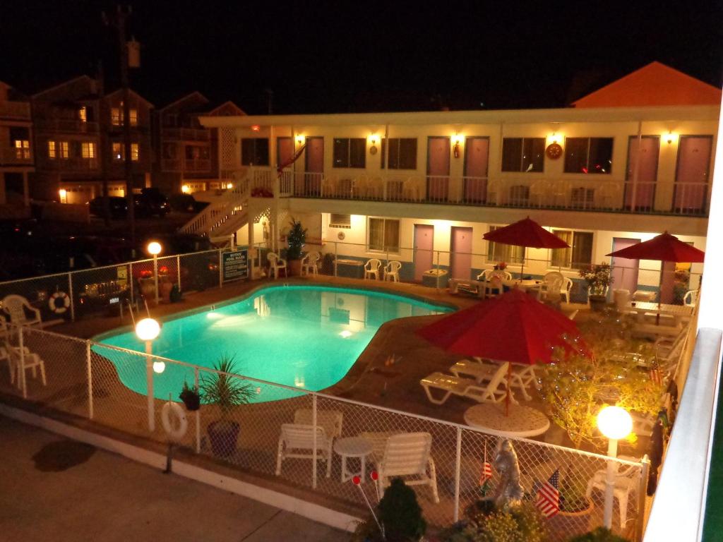 a view of a swimming pool at night at Fountain Motel in Wildwood