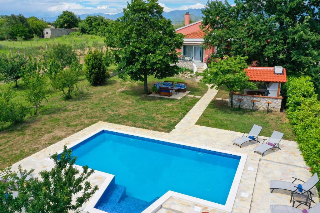 een uitzicht op een zwembad in een tuin met een huis bij EasyLiving House near Zadar in Posedarje
