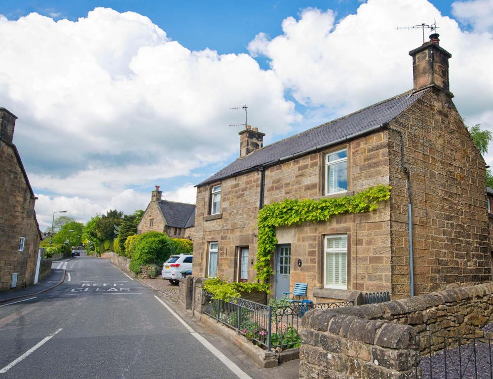 una casa de ladrillo con hiedra al lado de una calle en One Church Street, en Matlock