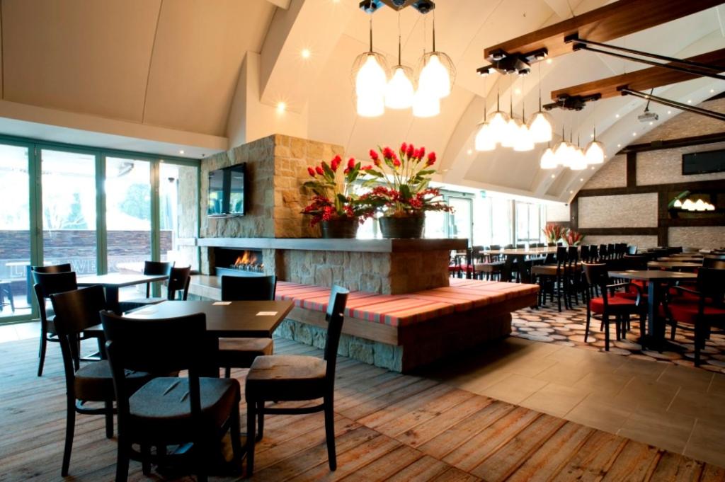 um restaurante com mesas e cadeiras e uma lareira em Springs Mittagong em Mittagong