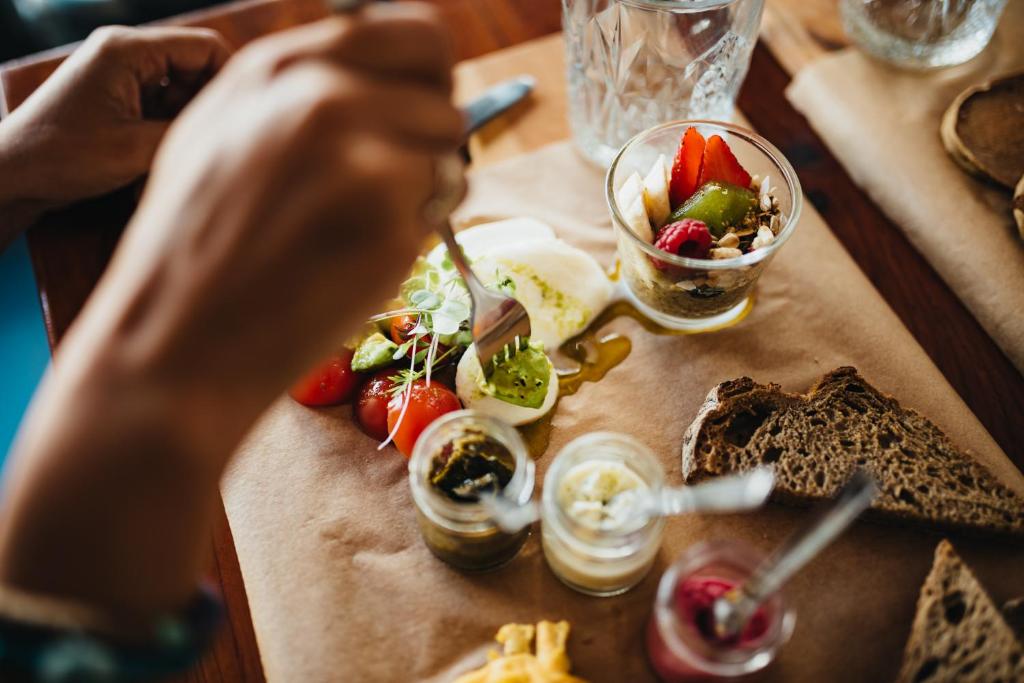 a person is eating food on a table at GiG Capsule Hostel in Ericeira