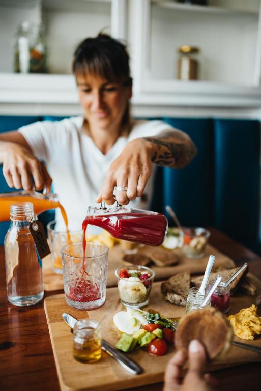 a woman pouring sauce into a glass on a table at GiG Capsule Hostel in Ericeira