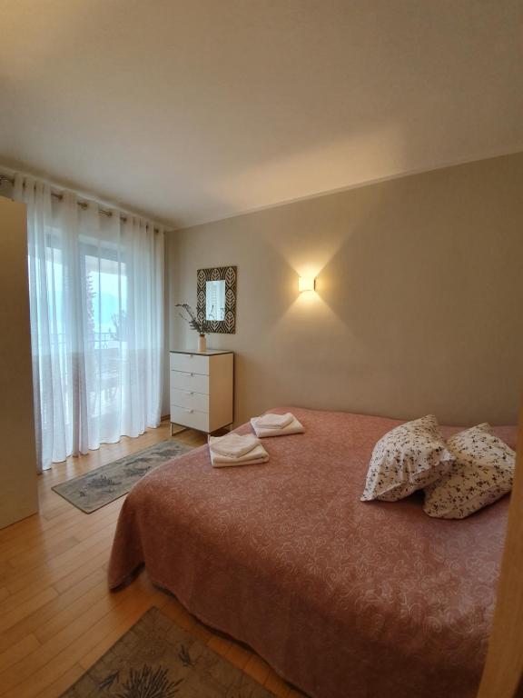 a bedroom with a bed and a dresser and a window at Apartment Maniva in Kotor