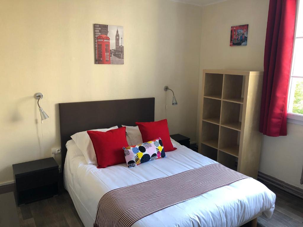 1 dormitorio con 1 cama con almohadas rojas en Le petit poucet en Saint Lo
