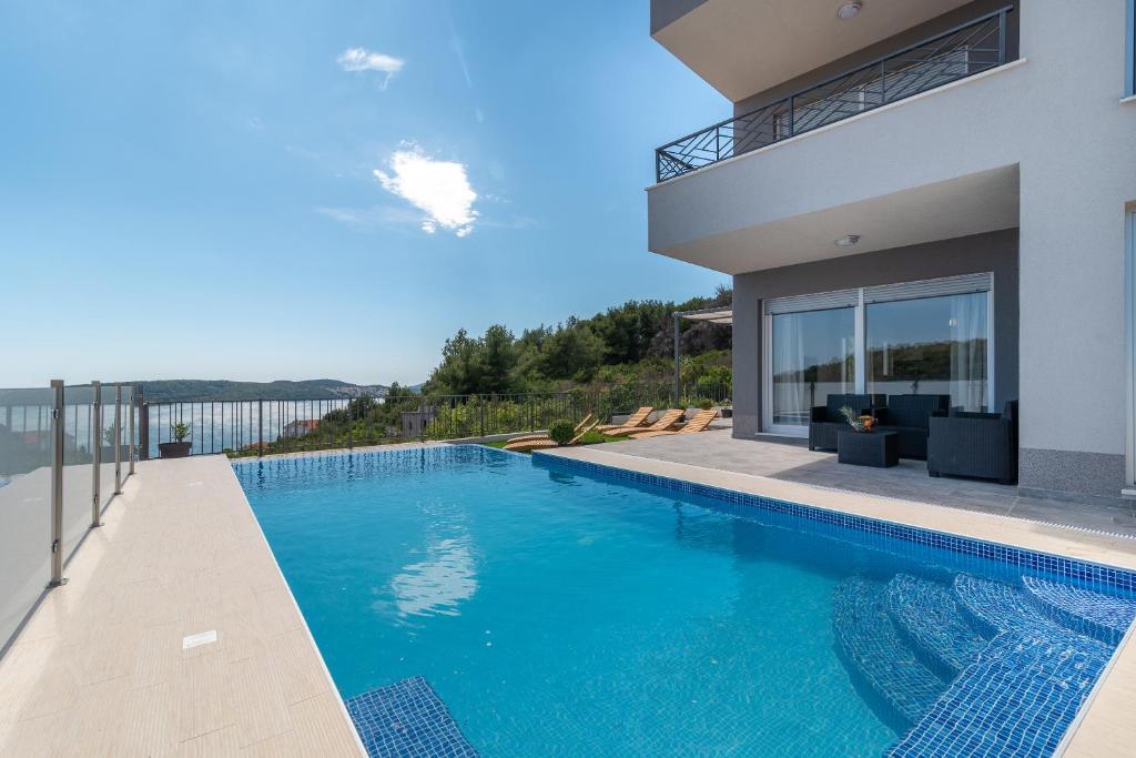 ein Pool vor einem Haus in der Unterkunft Holiday home Trogir-Ciovo Villa Goldy in Trogir