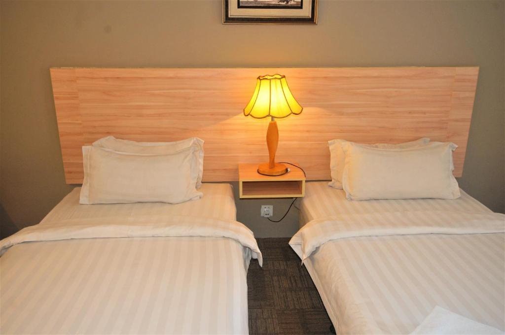 Postel nebo postele na pokoji v ubytování Prima Hotel Melaka
