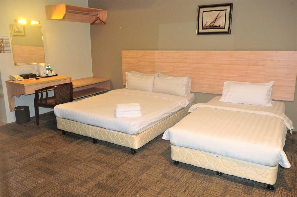 Postel nebo postele na pokoji v ubytování Prima Hotel Melaka