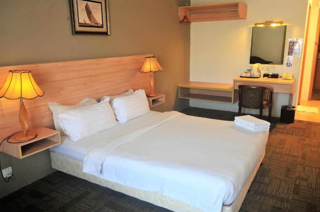 Postel nebo postele na pokoji v ubytování Prima Hotel Melaka