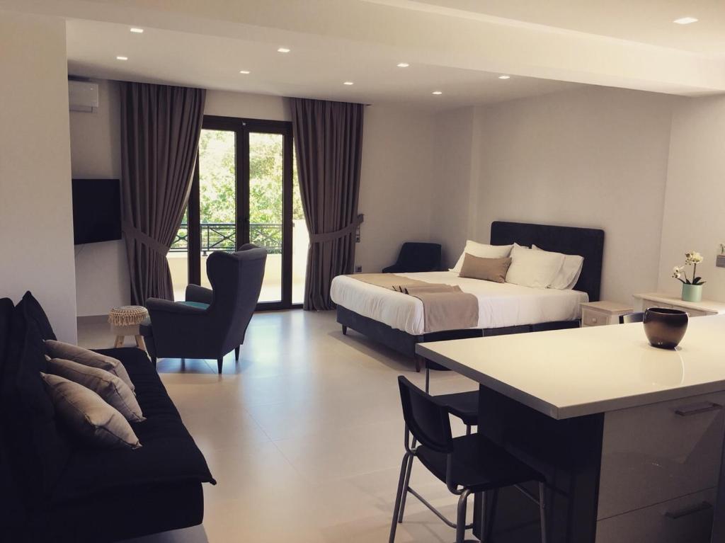 Habitación de hotel con cama, mesa y sillas en The Little Prince Luxury Suites, en Ýpsos