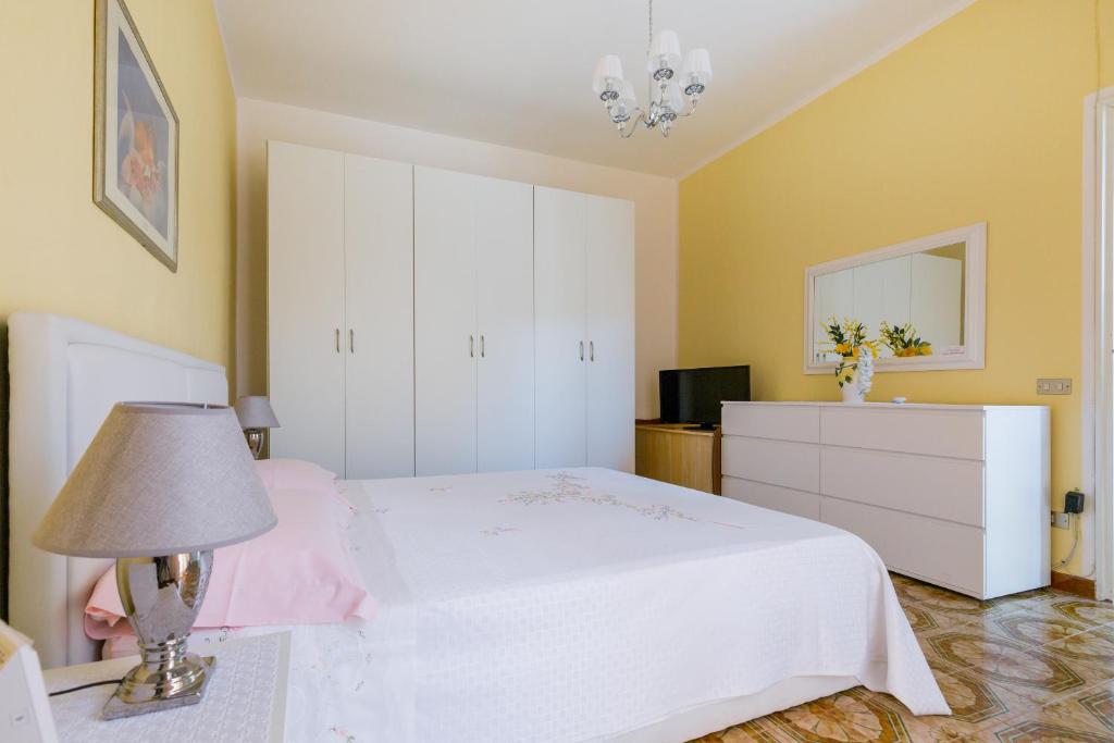 諾托的住宿－Casa La Formica，卧室配有白色的床和灯