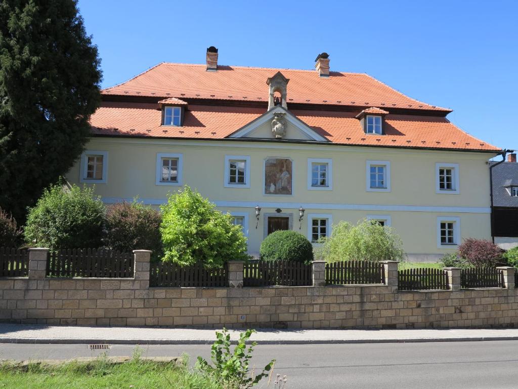 una grande casa bianca con tetto rosso di Zámecký penzion Sloup a Sloup