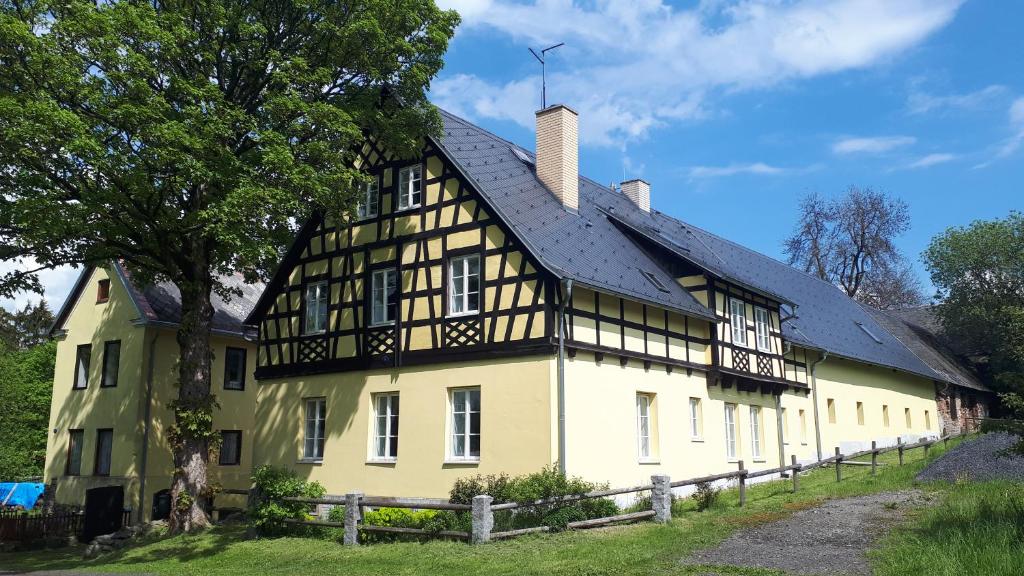 an old yellow and black building with a black roof at Päitara Hof in Mariánské Lázně