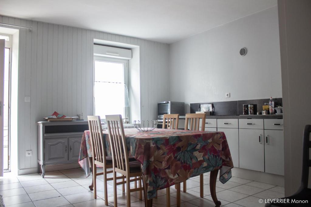 a kitchen with a table with chairs and a table and a tablecloth at Logis des chouans in Les Landes-Génusson