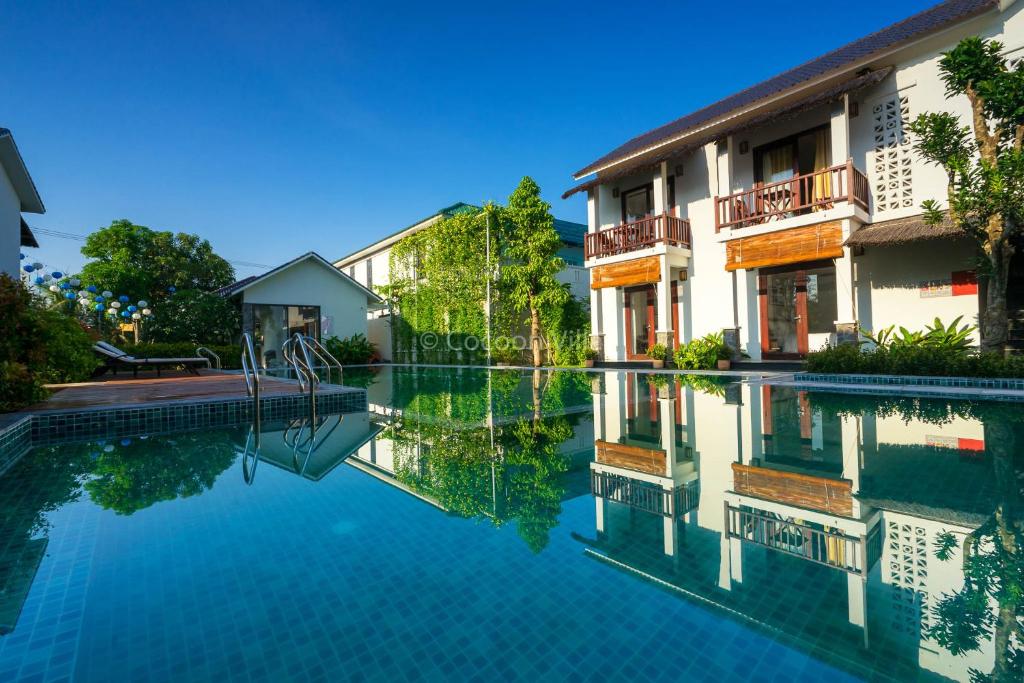 a swimming pool in front of a building at Cocoon Villa in Hoi An