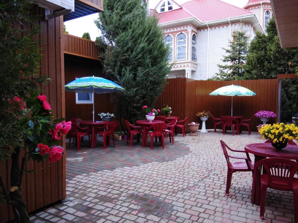 a patio with tables and chairs and umbrellas at Mini Hotel Уютный дворик in Odesa
