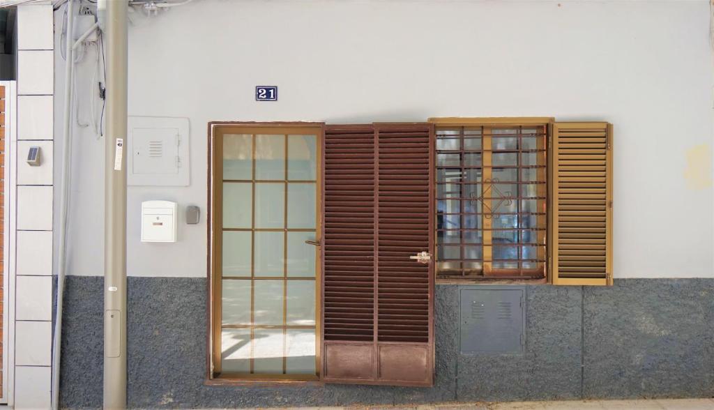 Casa Borguny - House in the centre of Palma في بالما دي ميورقة: باب خشبي ونافذة على جانب المبنى