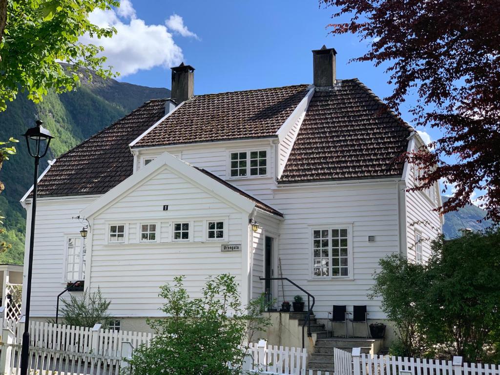 una casa bianca con una recinzione di fronte di Høyanger 3 roms leilighet a Høyanger