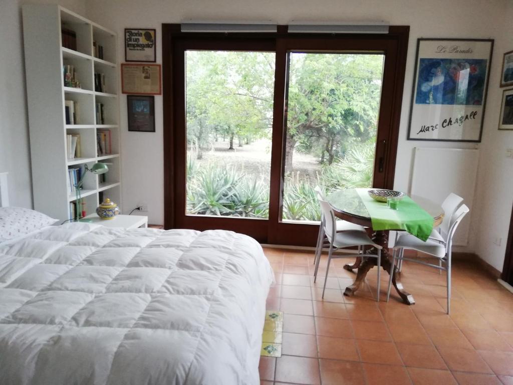 a bedroom with a bed and a table and a window at Casa Gelsomino in Carlentini