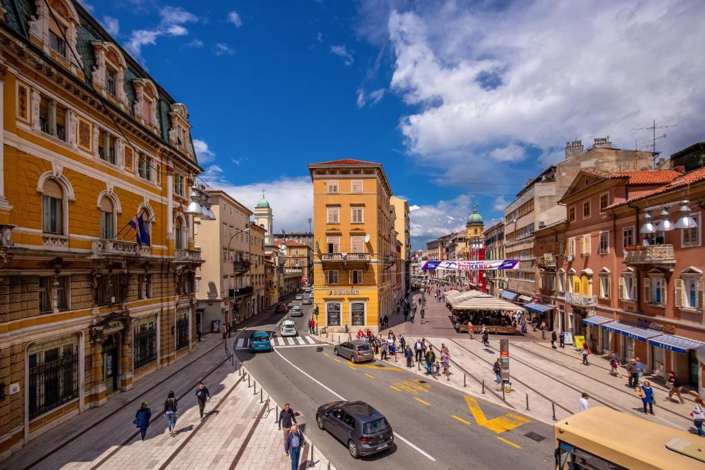a busy city street with people and cars on the road at Forever apartment & rooms in Rijeka