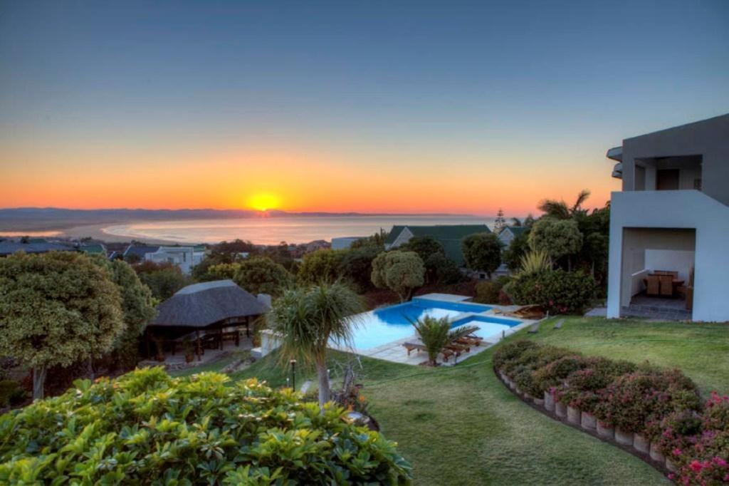 einen Sonnenuntergang über einer Villa mit einem Pool in der Unterkunft The Ocean Bay Luxury Guesthouse in Jeffreys Bay