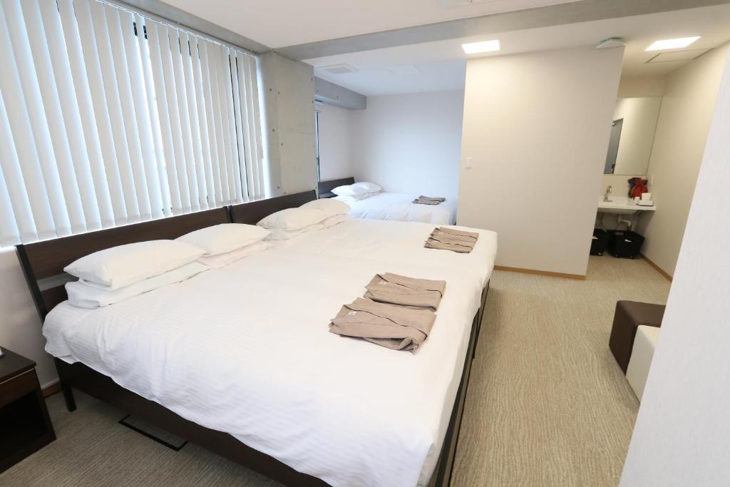 Postel nebo postele na pokoji v ubytování Business Capsule Hotel Lightning Hotel Asakusa