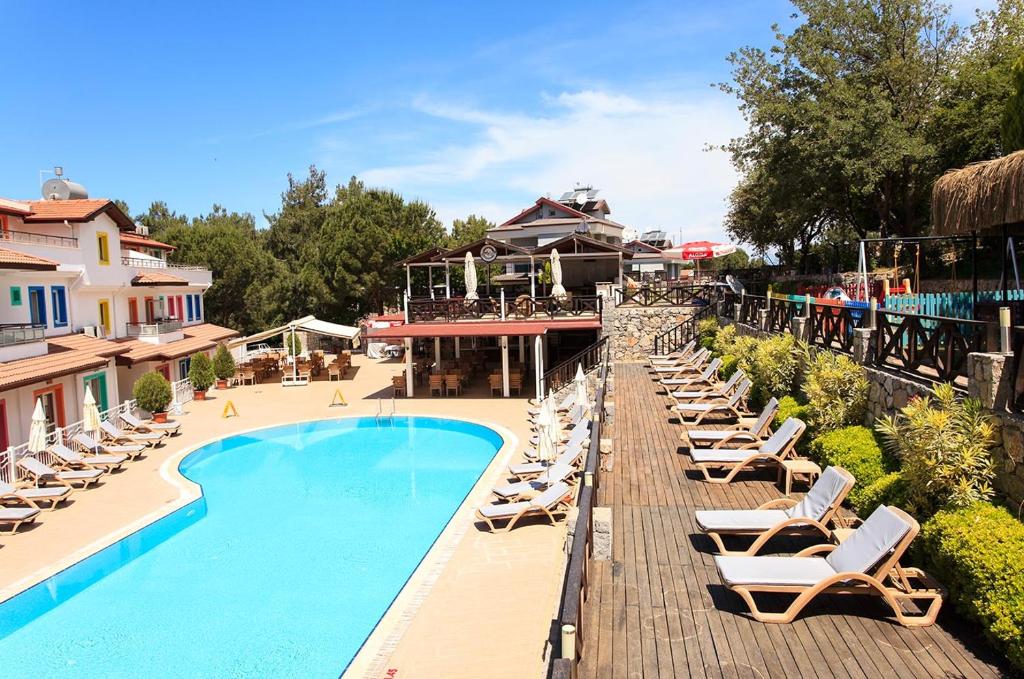 um resort com piscina e espreguiçadeiras em Konfor Suite Otel em Oludeniz