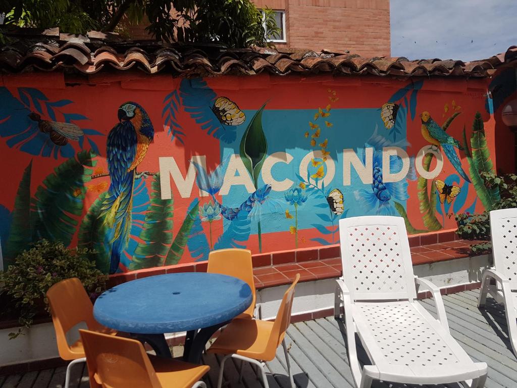 a table and chairs in front of a mural with the word mexico at Macondo Hostel in San Gil