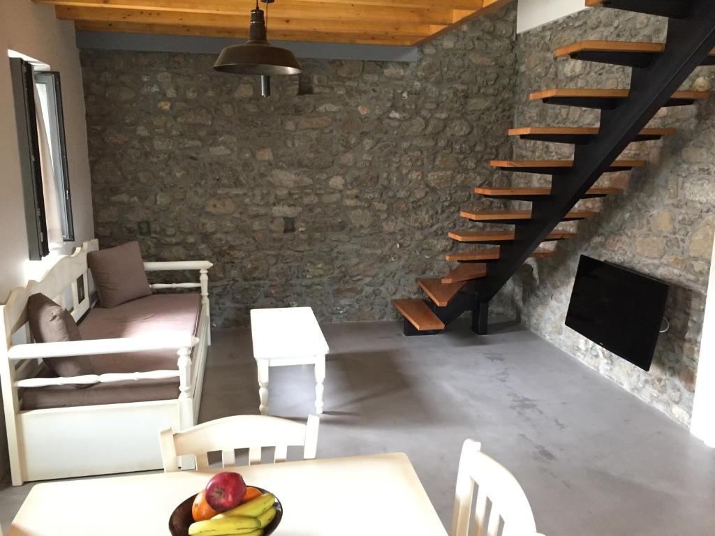 a living room with a staircase and a table and chairs at Loukia in Kondiás