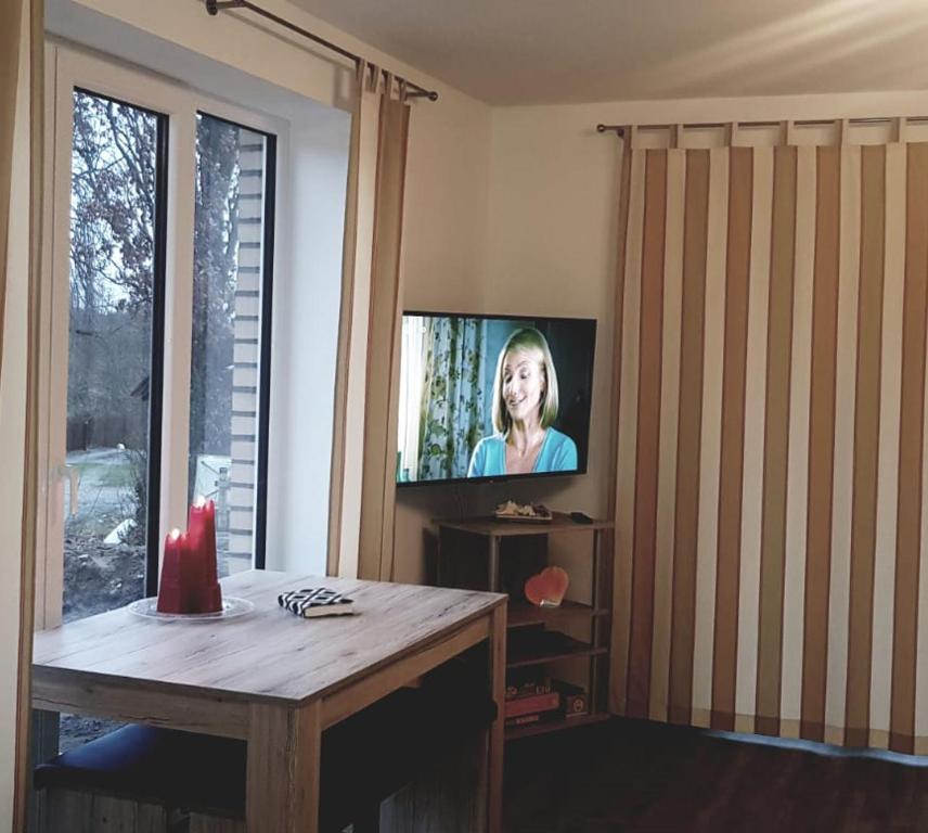 uma sala de estar com uma televisão e uma mesa de madeira em Ferienwohnung Ostseepalast em Timmendorfer Strand