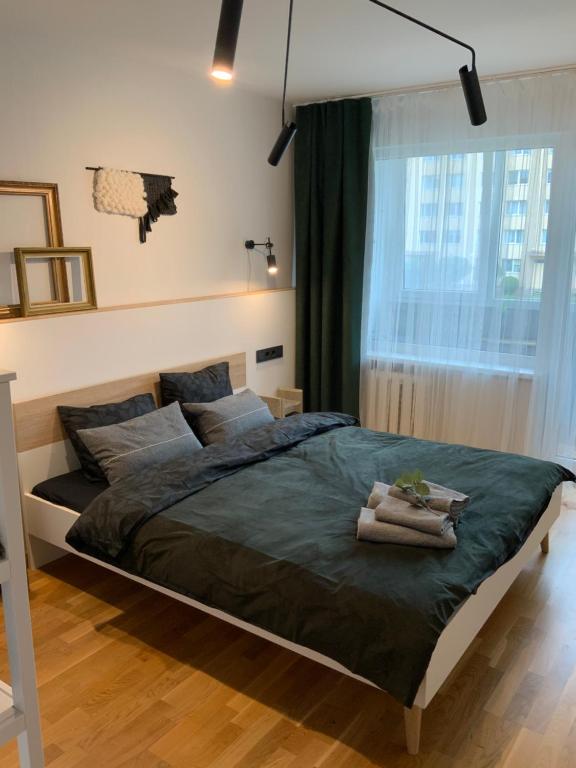 a bedroom with a large bed with towels on it at SouthWest Seashore Apartment in Liepāja