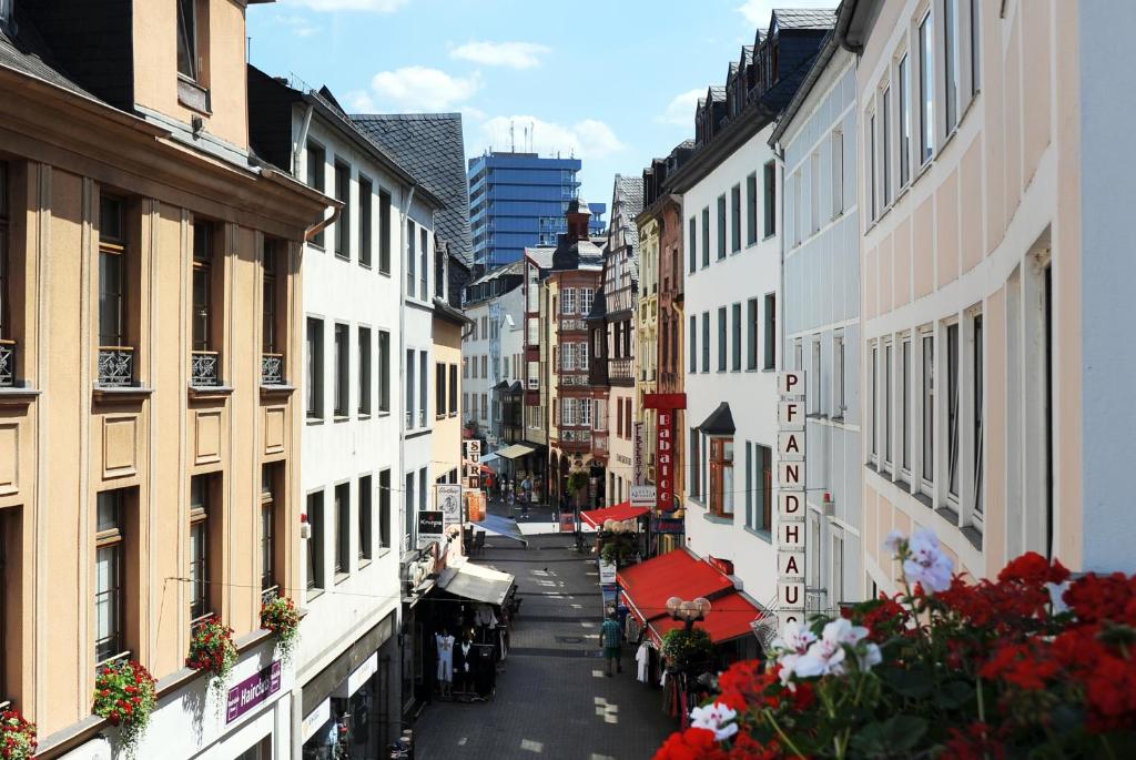 a city street with buildings and flowers on the side at Boardinghaus Koblenz Altstadt in Koblenz